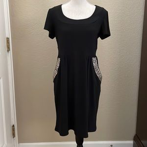 Black dress with grommet pockets.